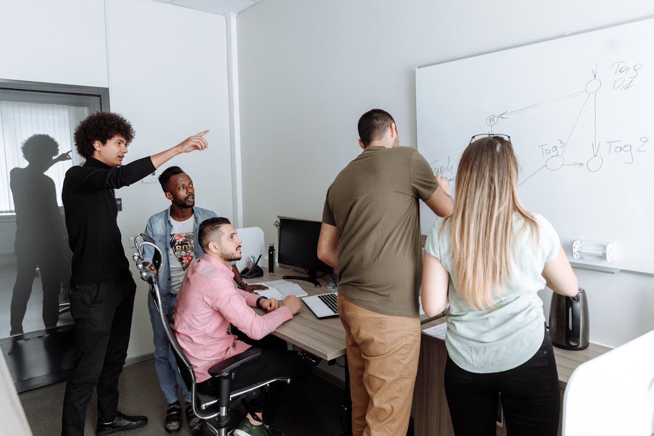 about-us-01 A diverse group of young professionals brainstorming together in a modern office setting.
